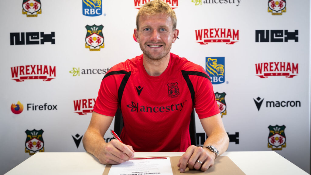 Joe Worrall assinando contrato com o Wrexham